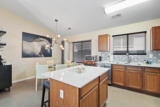 kitchen featuring appliances with stainless steel finishes, visible vents, a sink, and backsplash