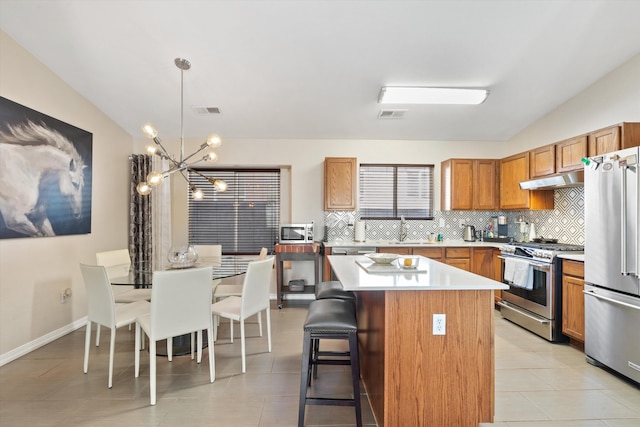 kitchen featuring tasteful backsplash, appliances with stainless steel finishes, visible vents, and under cabinet range hood