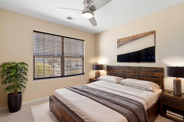 carpeted bedroom featuring a ceiling fan, visible vents, and baseboards