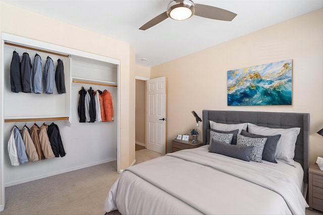 carpeted bedroom with a ceiling fan, a closet, and baseboards