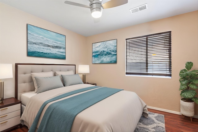 bedroom featuring baseboards, visible vents, ceiling fan, and wood finished floors