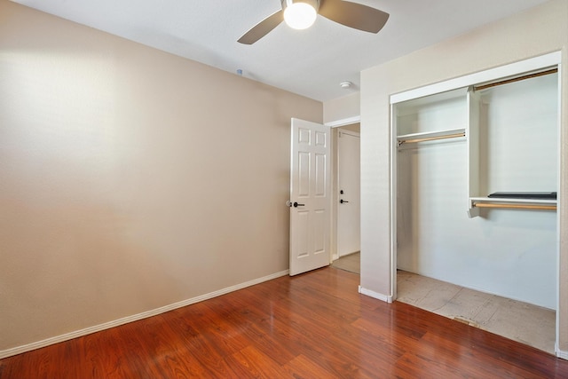 unfurnished bedroom featuring baseboards, a closet, a ceiling fan, and wood finished floors