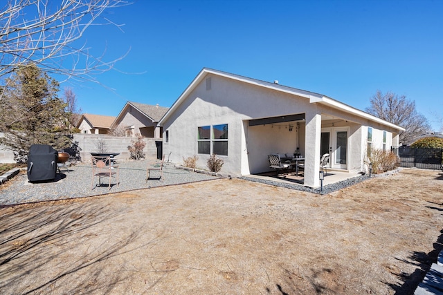 rear view of house featuring french doors, a patio area, a fenced backyard, and stucco siding