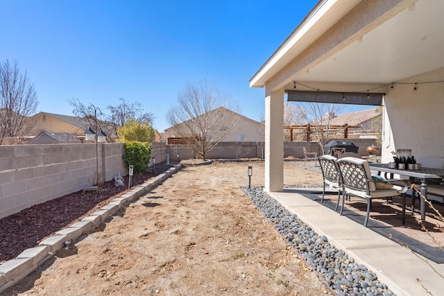 view of yard with outdoor dining area, a patio area, and a fenced backyard