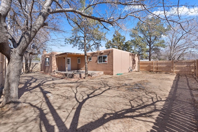 back of property with a fenced backyard and stucco siding