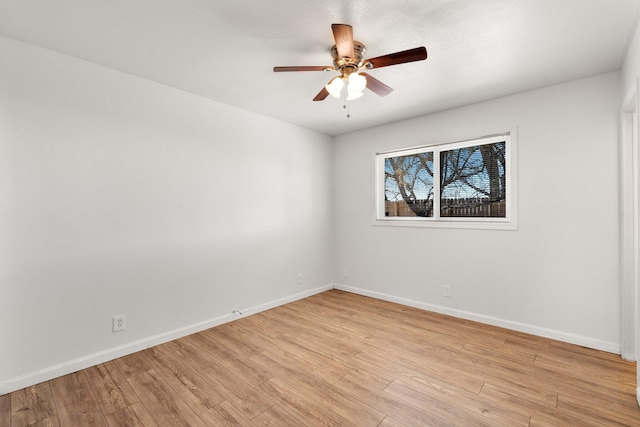 spare room with light wood-style floors, baseboards, and a ceiling fan