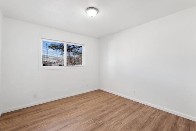 spare room with light wood-style floors and baseboards