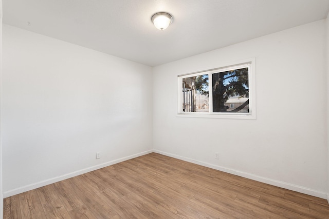 empty room featuring light wood-type flooring and baseboards