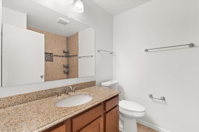 bathroom with tiled shower, vanity, and toilet