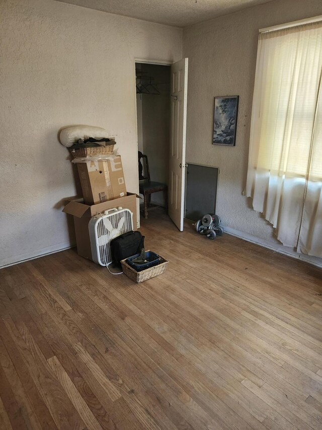 interior space with a textured wall and wood finished floors