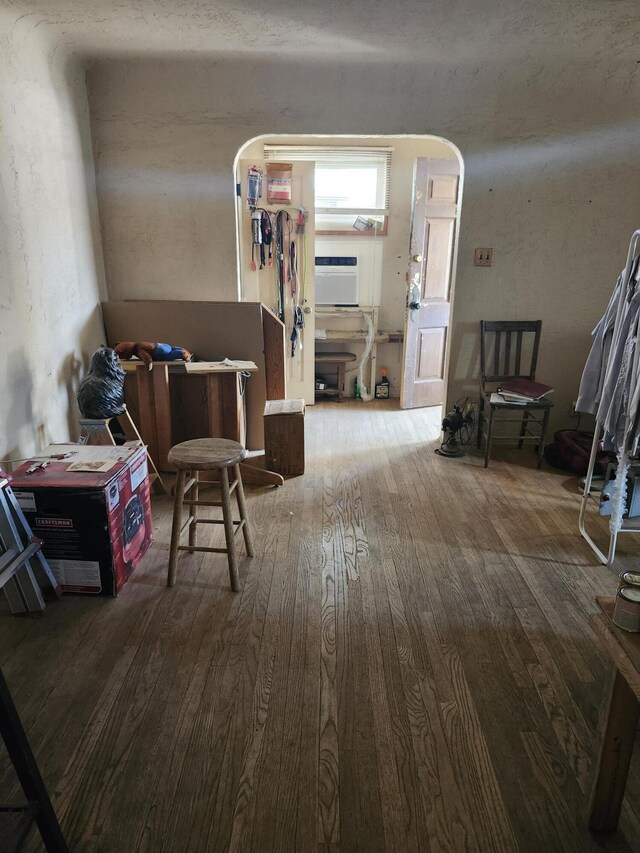 misc room featuring arched walkways and wood-type flooring