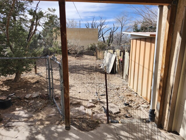 view of yard with a gate, fence, and an outbuilding