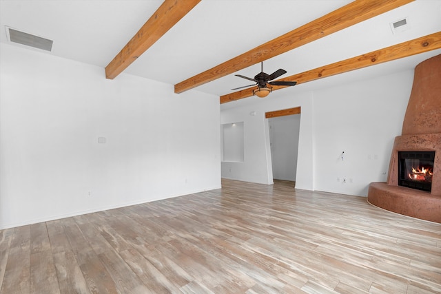 unfurnished living room featuring visible vents, a fireplace, and light wood-style flooring