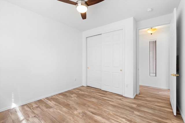 unfurnished bedroom with baseboards, ceiling fan, a closet, and light wood-style floors