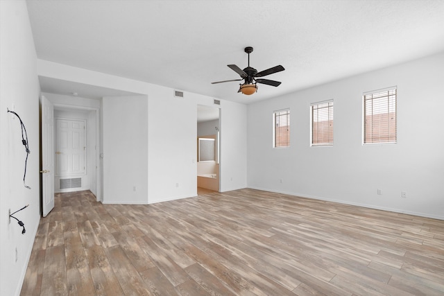 spare room featuring visible vents, ceiling fan, light wood-style flooring, and baseboards