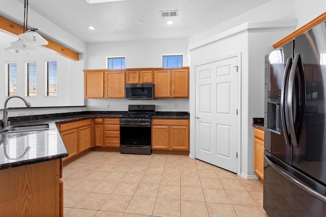 kitchen with light tile patterned floors, gas range oven, visible vents, black fridge with ice dispenser, and a sink