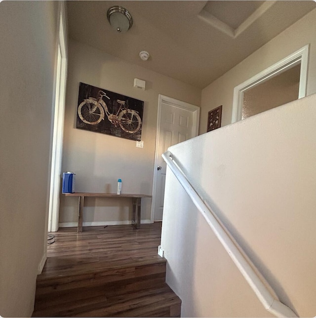 hallway featuring dark wood finished floors and baseboards