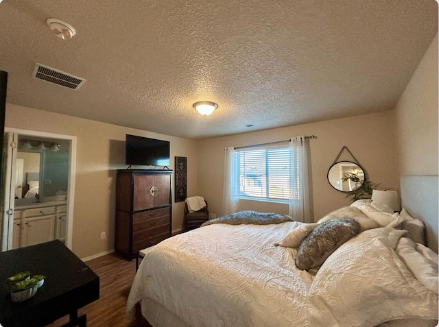 bedroom with dark wood-style floors, visible vents, and baseboards