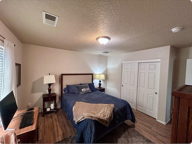 bedroom with a closet, visible vents, and wood finished floors