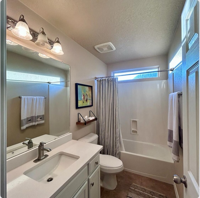 bathroom featuring toilet, tile patterned flooring, shower / bath combo with shower curtain, a textured ceiling, and vanity