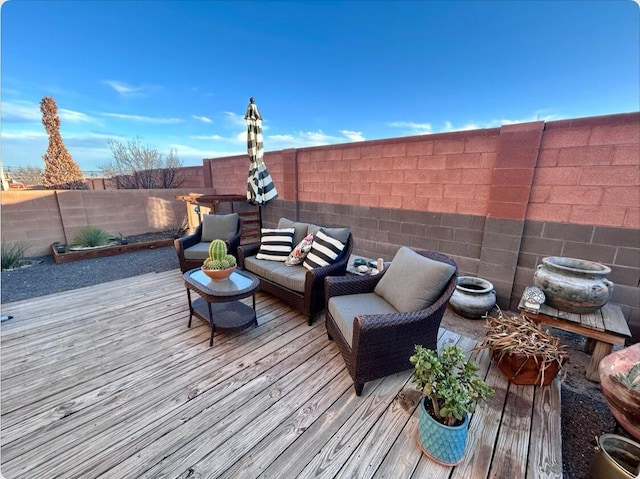 wooden deck featuring outdoor lounge area and a fenced backyard