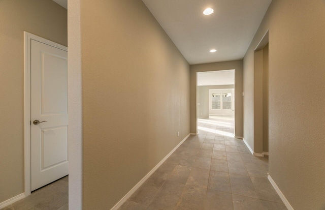 hall with light tile patterned floors, baseboards, and recessed lighting