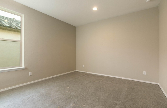 empty room featuring carpet floors, baseboards, and recessed lighting