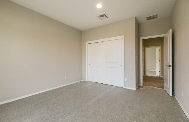 unfurnished bedroom featuring carpet floors, baseboards, and visible vents