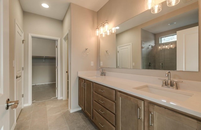 full bathroom featuring double vanity, a stall shower, tile patterned flooring, and a sink