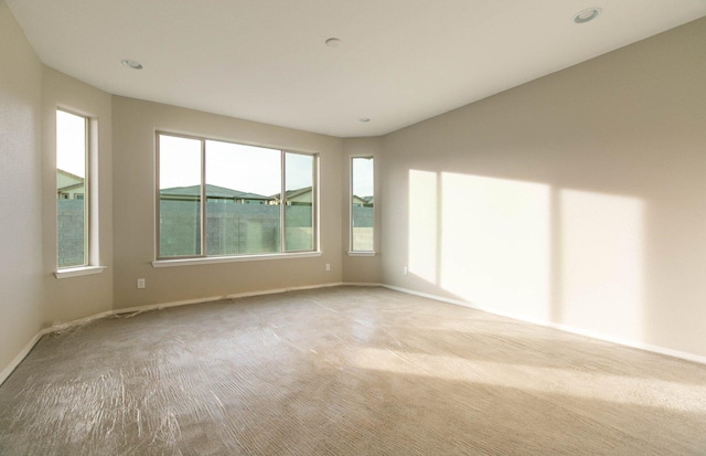 carpeted spare room featuring baseboards