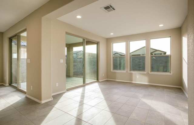 spare room with baseboards, visible vents, and a wealth of natural light