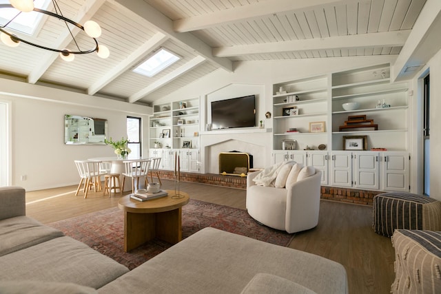 living area with vaulted ceiling with skylight, wooden ceiling, a fireplace with raised hearth, and wood finished floors