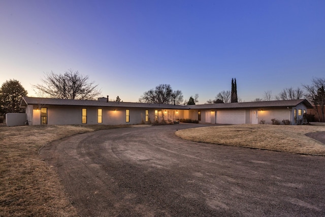 view of front of property featuring dirt driveway and an attached garage