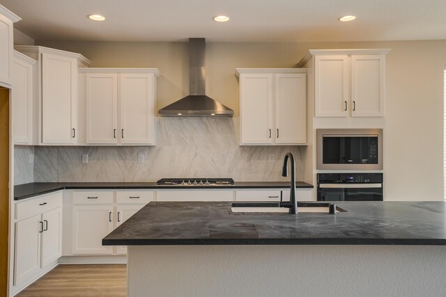 6209 Angelou Ln NW, Albuquerque, NM 87120 - kitchen featuring wall chimney range hood, appliances with stainless steel finishes, a sink, white cabinetry, and recessed lighting