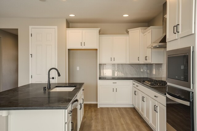6209 Angelou Ln NW, Albuquerque, NM 87120 - kitchen featuring stainless steel appliances, a sink, light wood finished floors, white cabinets, and tasteful backsplash