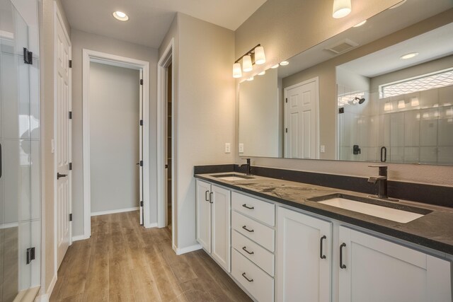 6209 Angelou Ln NW, Albuquerque, NM 87120 - full bathroom featuring double vanity, wood finished floors, a stall shower, recessed lighting, and baseboards