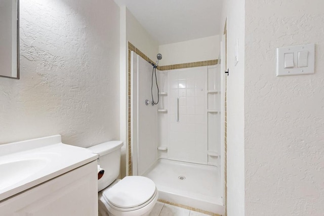 bathroom with a textured wall, vanity, walk in shower, and toilet