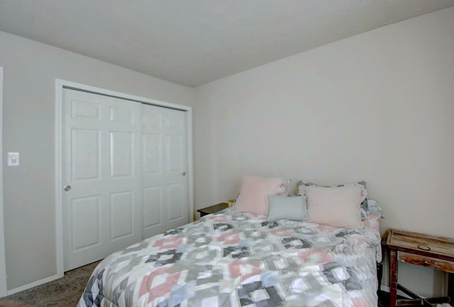 carpeted bedroom with a closet and baseboards