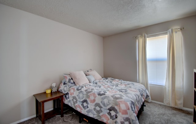 bedroom featuring a textured ceiling, baseboards, and carpet floors