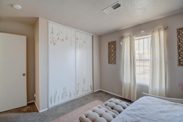 bedroom featuring visible vents, carpet flooring, a textured ceiling, and baseboards