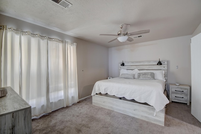 bedroom with visible vents, carpet floors, and a textured ceiling