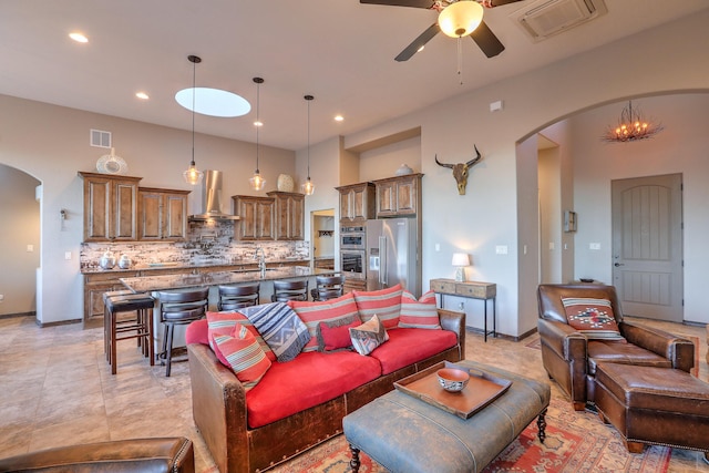 living room with a ceiling fan, arched walkways, visible vents, and recessed lighting