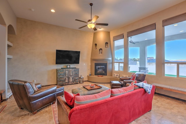 living room featuring recessed lighting, ceiling fan, and a glass covered fireplace