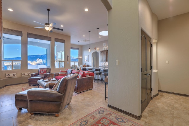 living room with arched walkways, ceiling fan, recessed lighting, visible vents, and baseboards