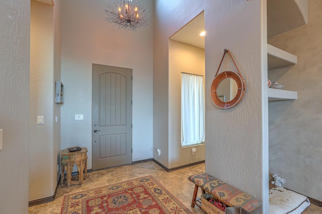 foyer featuring baseboards and an inviting chandelier