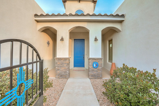 entrance to property with stone siding and stucco siding