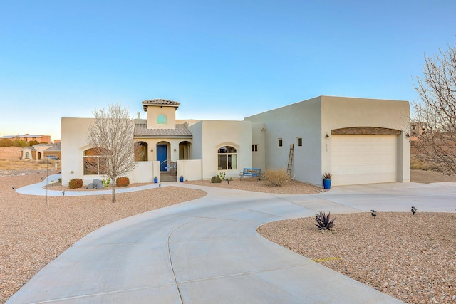 view of front of home with driveway, an attached garage, and stucco siding