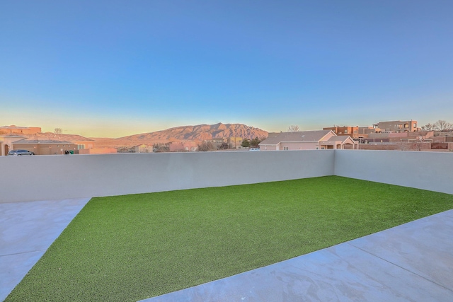 view of yard with a fenced backyard, a mountain view, and a patio