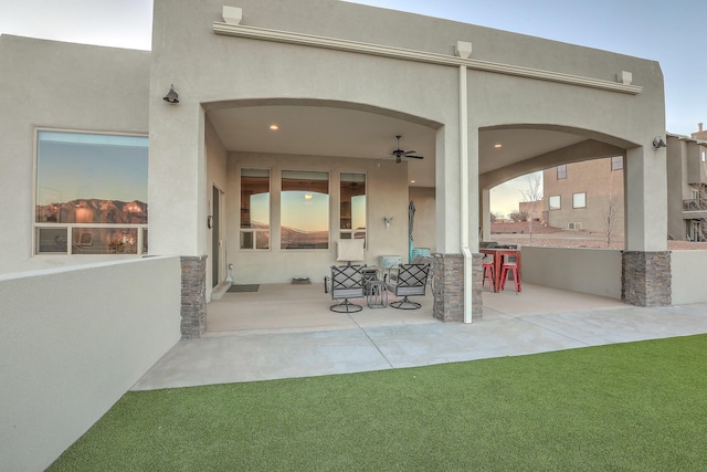 rear view of property featuring a patio and stucco siding