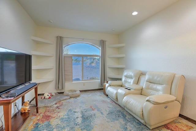 living area with baseboards, recessed lighting, and built in features